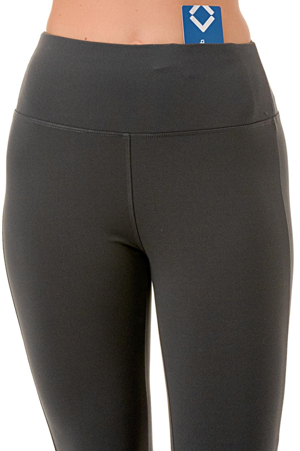 May include: Charcoal gray leggings with a high waistband. The leggings have a smooth, opaque appearance and a vertical seam down the center of the legs. A blue card is partially tucked into the waistband.